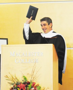 Convocation speaker Richard Blanco holds up his new honorary degree from Macalester for all to see. Blanco spoke to a crowded Kagin this week on the topics of national and personality identity, including readings from his original works. Photo by Alex Bentz ’14.