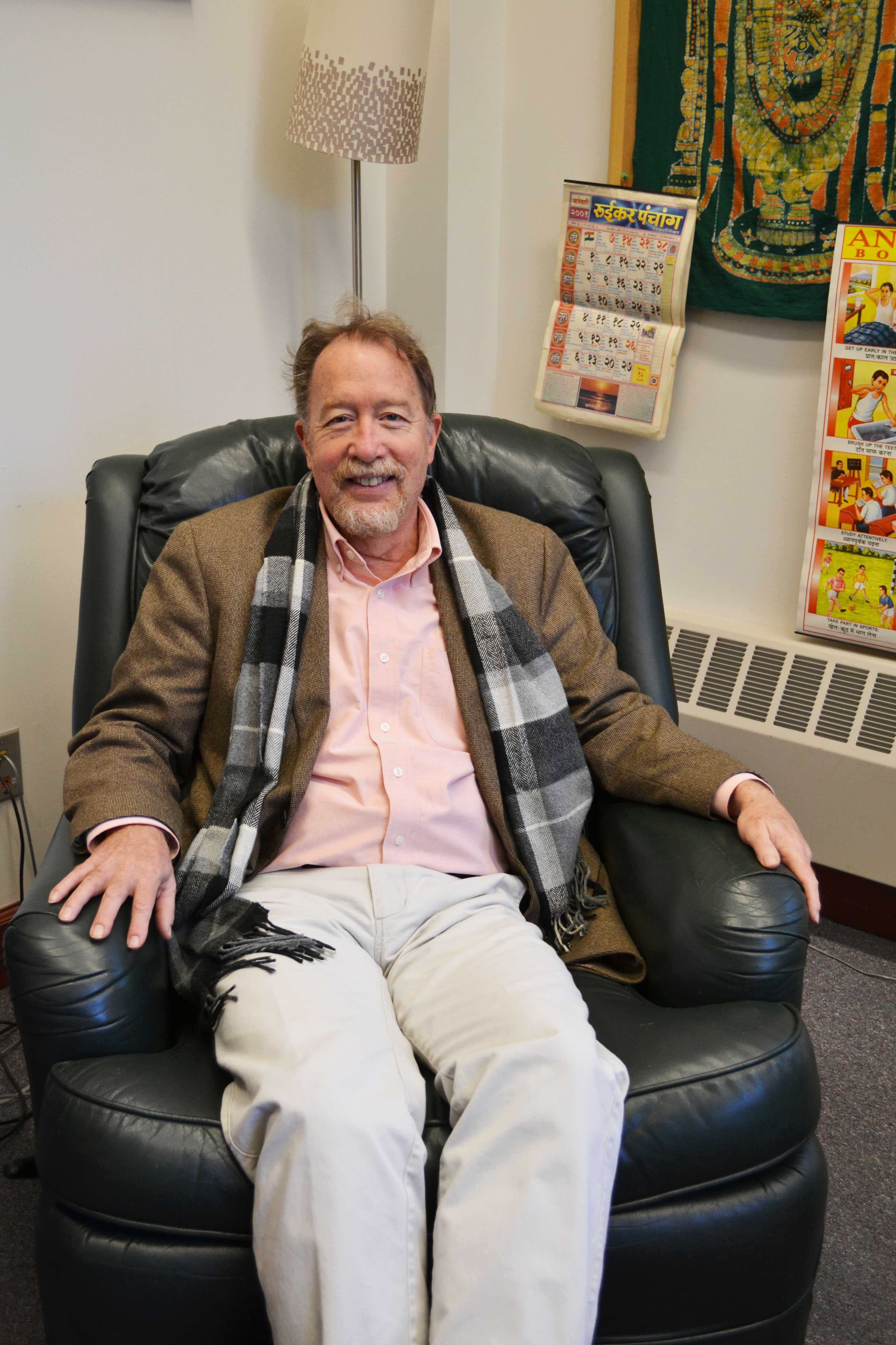 Professor Jim Laine poses alongside his office decorations. Photo by Alta Connors ’19.