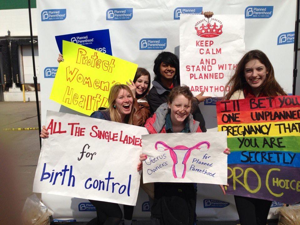 Students display signs in support of Planned Parenthood. Mac Dems helped organize a Good Friday Solidarity rally at the St. Paul clinic. Left to right, front row: Abby Tuominen 16, Margaret Mulligan 16, Grace Petrie 16. Back row: Grace Woff 16 Rothin Datta 16. Photo courtesy of Margaret Mulligan 16. 