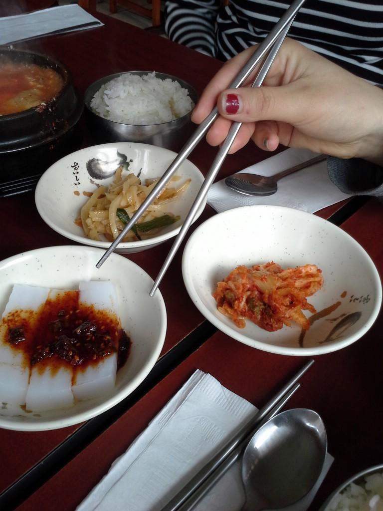 Camillle Cauchois ’13 digs into the side dishes accompanying the soondobu jigae at Kimchi Tofu House. 