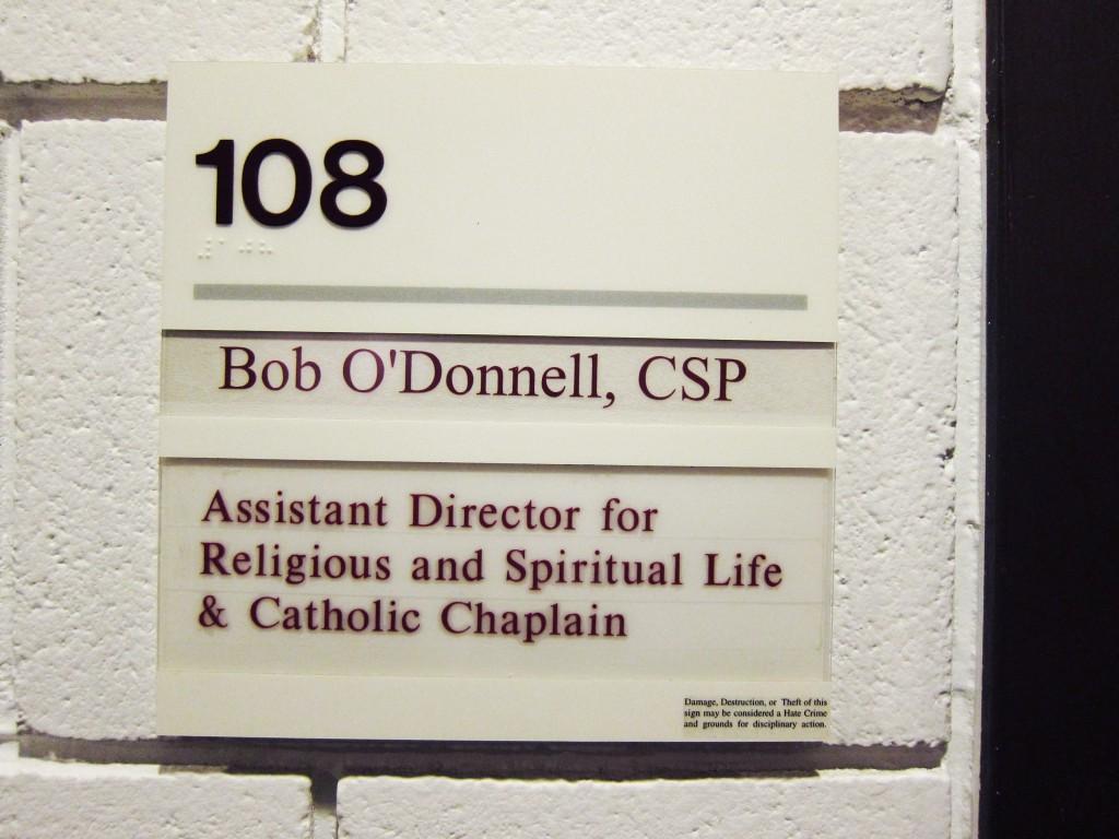 The sign outside the door to Catholic Chaplain Bob O’Donnell’s former office remains up, even after O’Donnell’s departure from Macalester. The CRSL is searching for a replacement priest after O’Donnell received word he would be reassigned elsewhere. Photo by Naomi Guttman ‘16.