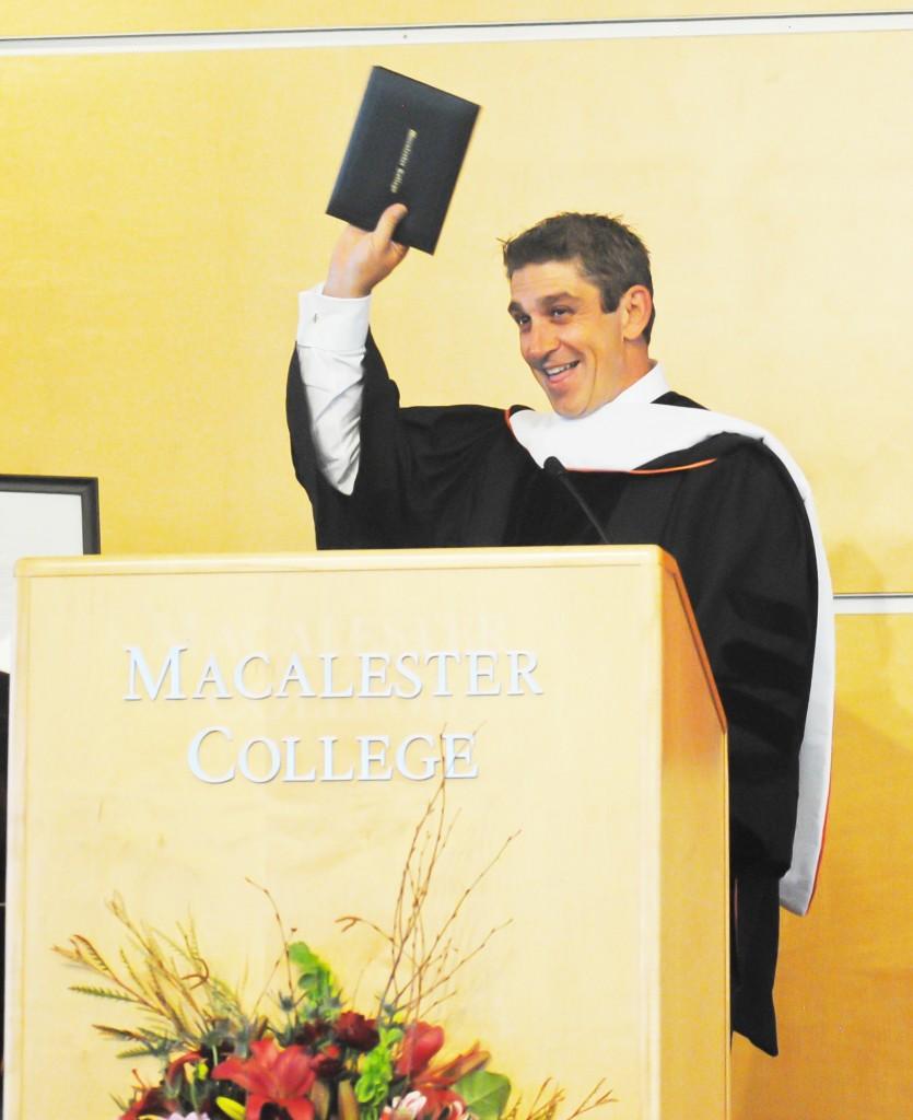 Convocation speaker Richard Blanco holds up his new honorary degree from Macalester for all to see. Blanco spoke to a crowded Kagin this week on the topics of national and personality identity, including readings from his original works. Photo by Alex Bentz ’14.