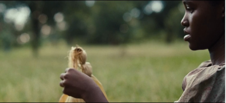 Patsey makes a doll out of corn husks after a day of working Epps’ cotton fields. Patsey, played by Lupita Nyong’o, is the only other slave the audience really gets attached to, yet is unable to escape slavery. Screenshot from the trailer for “12 Years A Slave,” Fox Searchlight Pictures. 