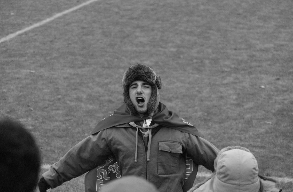 Devin Palmer ’15 leads the Macalester student section in a cheer during last Saturday’s women’s soccer game versus St. Benedict’s in Collegeville, Minn. Photo by Mark McCrae-Hokenson ’15.