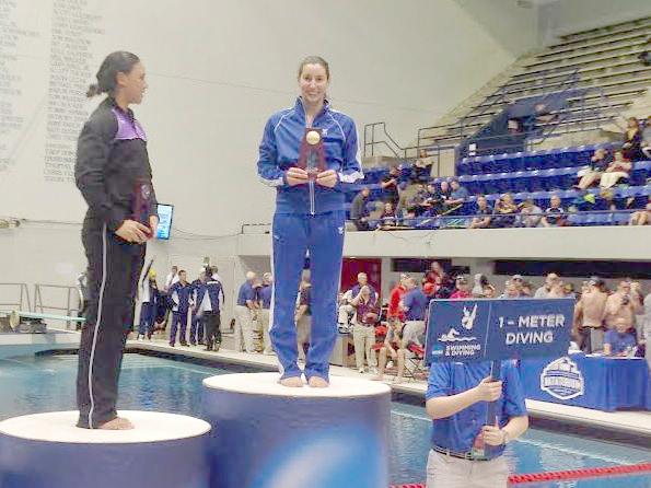 Renee Jordan stands on the podium after finishing first in the one-meter diving event at the NCAA Division III Swimming and Diving National Championships. Jordan’s achievement ranks as our top Mac sports moment of the 2013-14 academic year. Photo courtesy of Rene Jordan ‘14. 