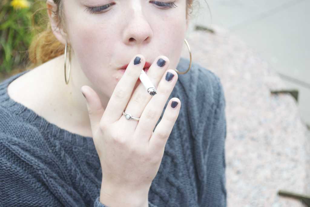 A student smokes on Bateman Plaza earlier this week. Effective January 1, smoking will be forbidden on campus. Photo by Joe Bermas-Dawes17.