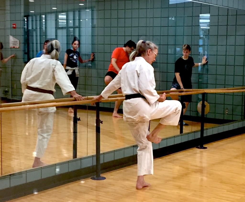 Bendickson demonstrates a kick while students mirror her.