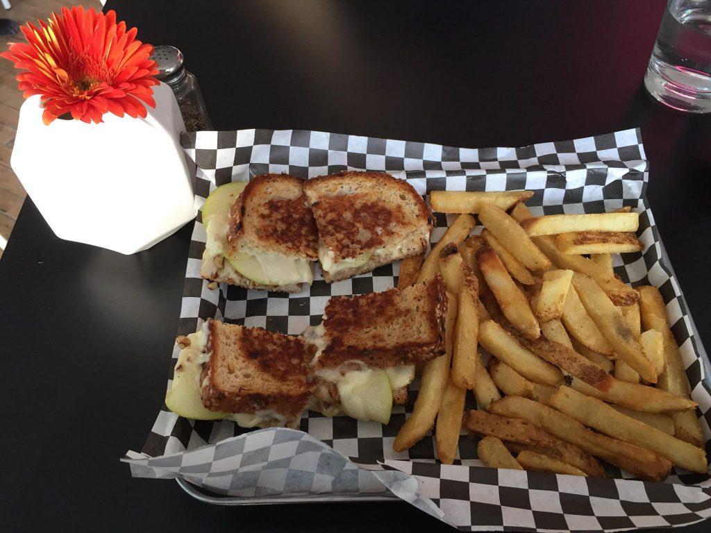 The apple-brie-pecan grilled cheese sandwich served with a side of seasoned fries. Photo by Meg Hinson ’19.