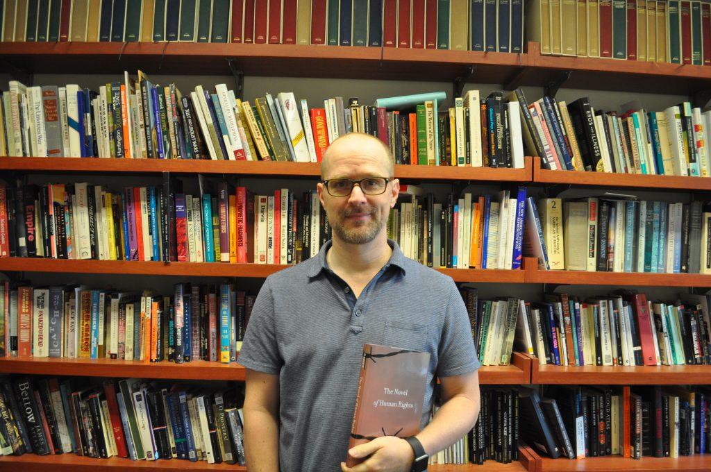 Professor Dawes poses with his new book. Photo by Malcolm Cooke ’21.