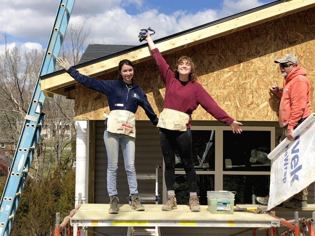 Miranda Moulis ’22, Emily McPhillips ’19 on a scaffold at the Habitat for Humanity build. Photo by Malcolm Cooke ’21.