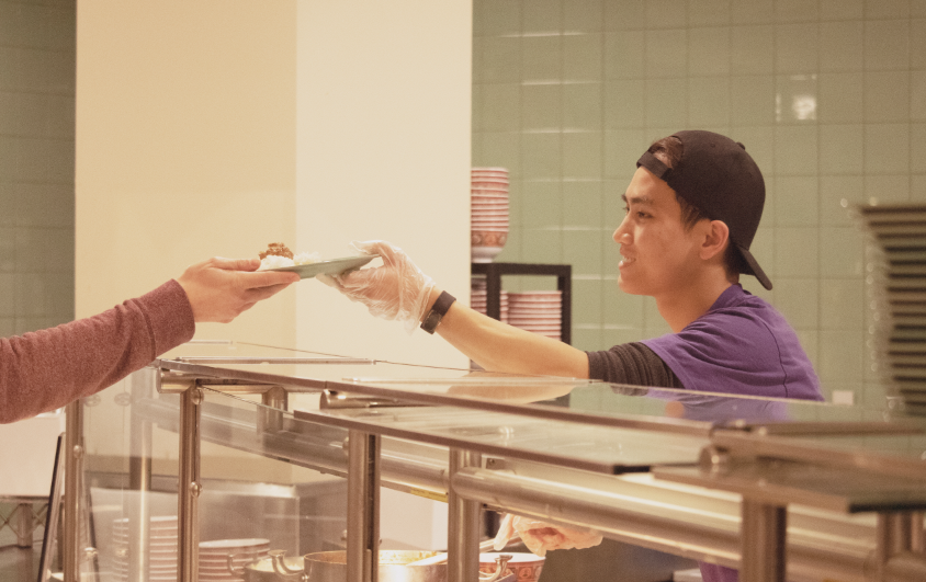 Cafe Mac student worker serves food. Photo by Shosuke Noma ’23.