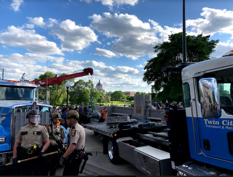 Workers from the Twin Cities Transport & Recovery company load the Christopher Columbus statue onto the back of a truck. Photo by Liam McMahon 20.