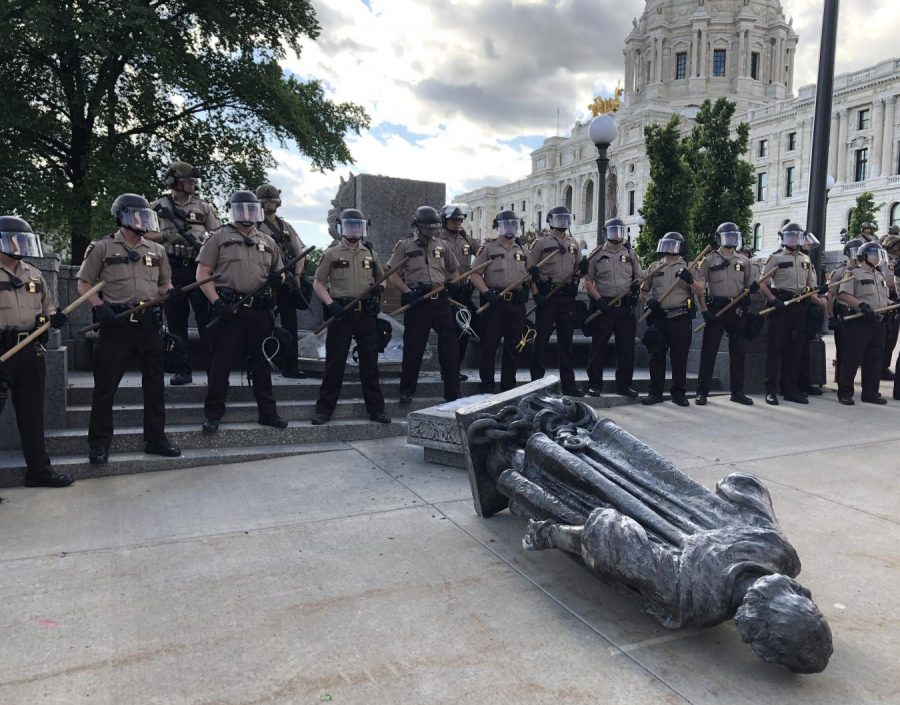 State troops guard the fallen statue of Christopher Columbus, which was toppled by Indigenous activists on June 10th. Photo by Abe Asher 20.