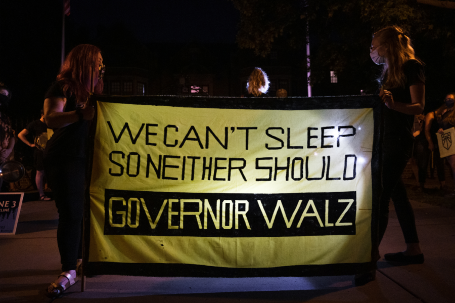 Protesters with Sunrise Movement Twin Cities hold a banner outside the governor’s mansion during the Wake Up Walz protest on Thursday night. Photo by Kori Suzuki ’21.