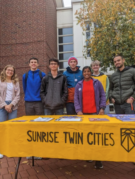 Members of Sunrise Macalester table with City Council Candidate Saura Jost and team.