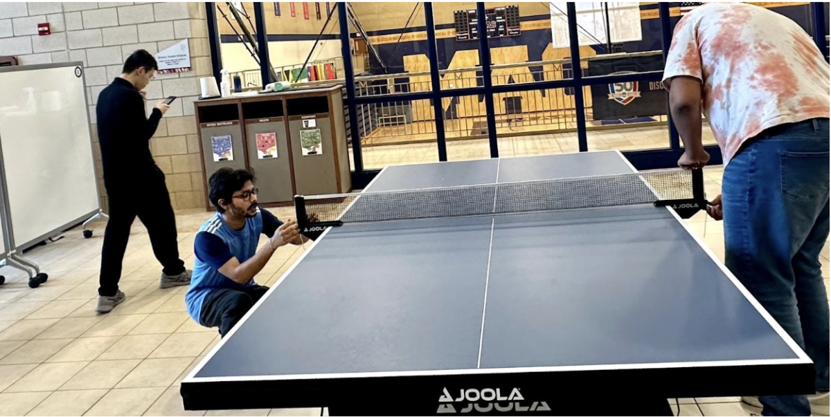 Chakrabarti prepares the ping pong table. Photo provided by Chakrabarti