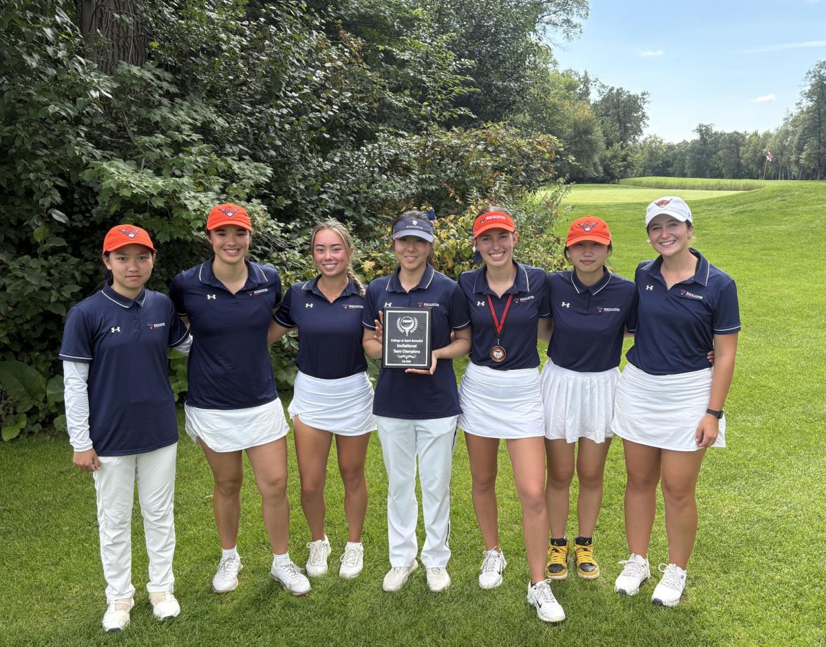 Women’s golf with their trophy after vistory at the SBI. Photo courtesy of Mac Athletics.